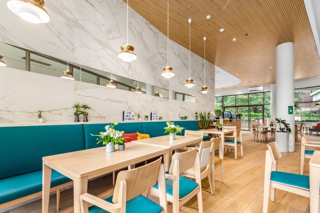 Cafe with teal banquette seating and timber tables