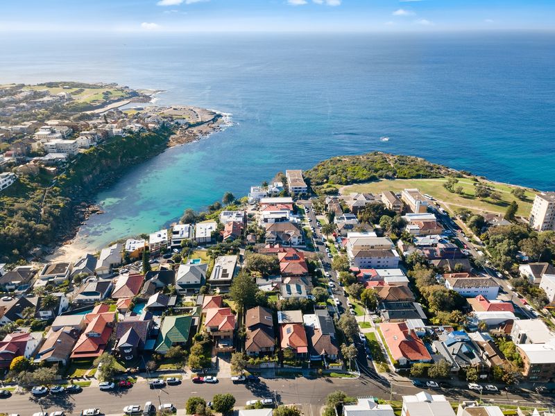 Aerial view of coastal homes beside a rocky bay