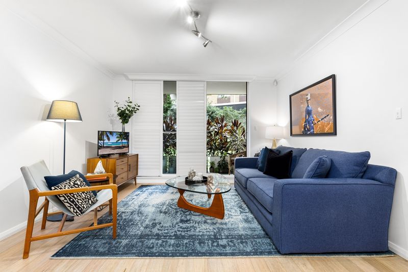 Living room with a blue sofa and patterned rug