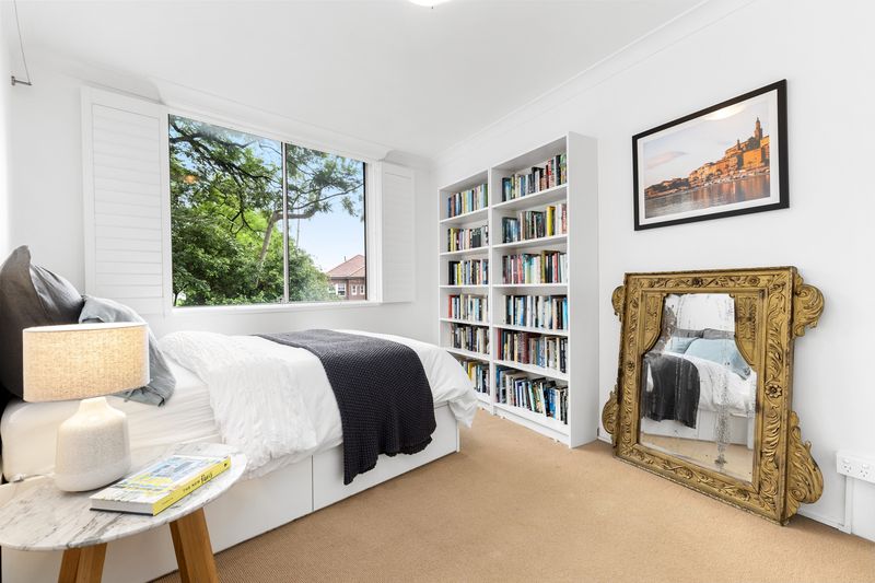 Bedroom with bookshelves and a gilded mirror
